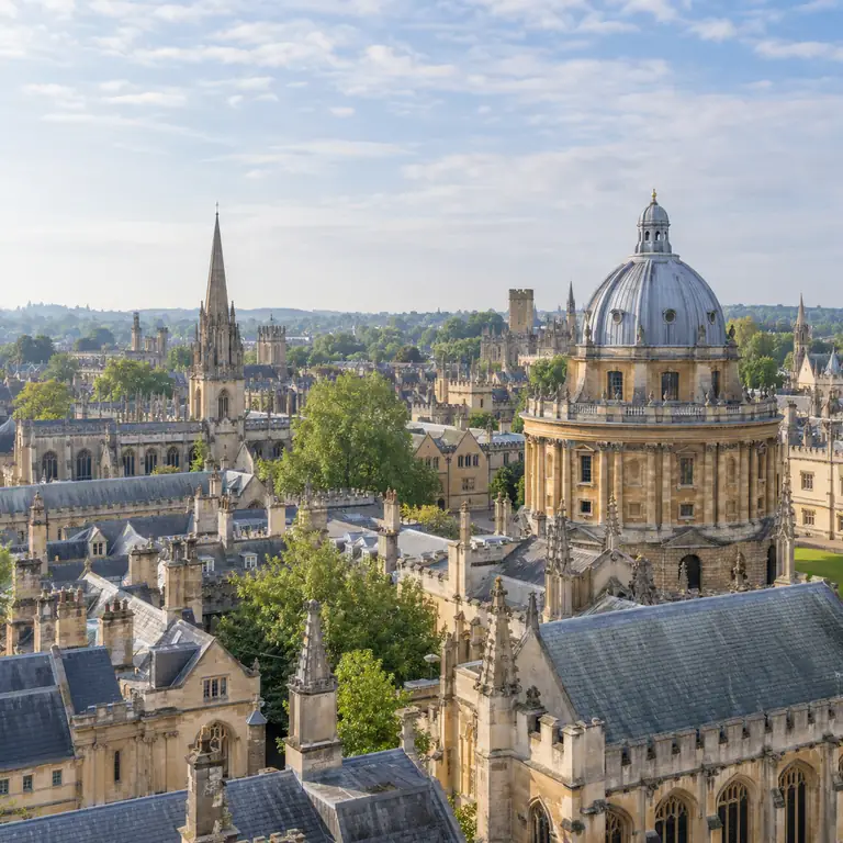 Oxford’un taş kuleleri, kubbeleri ve çatıları açık renk sabah gökyüzünün altında görünüyor.